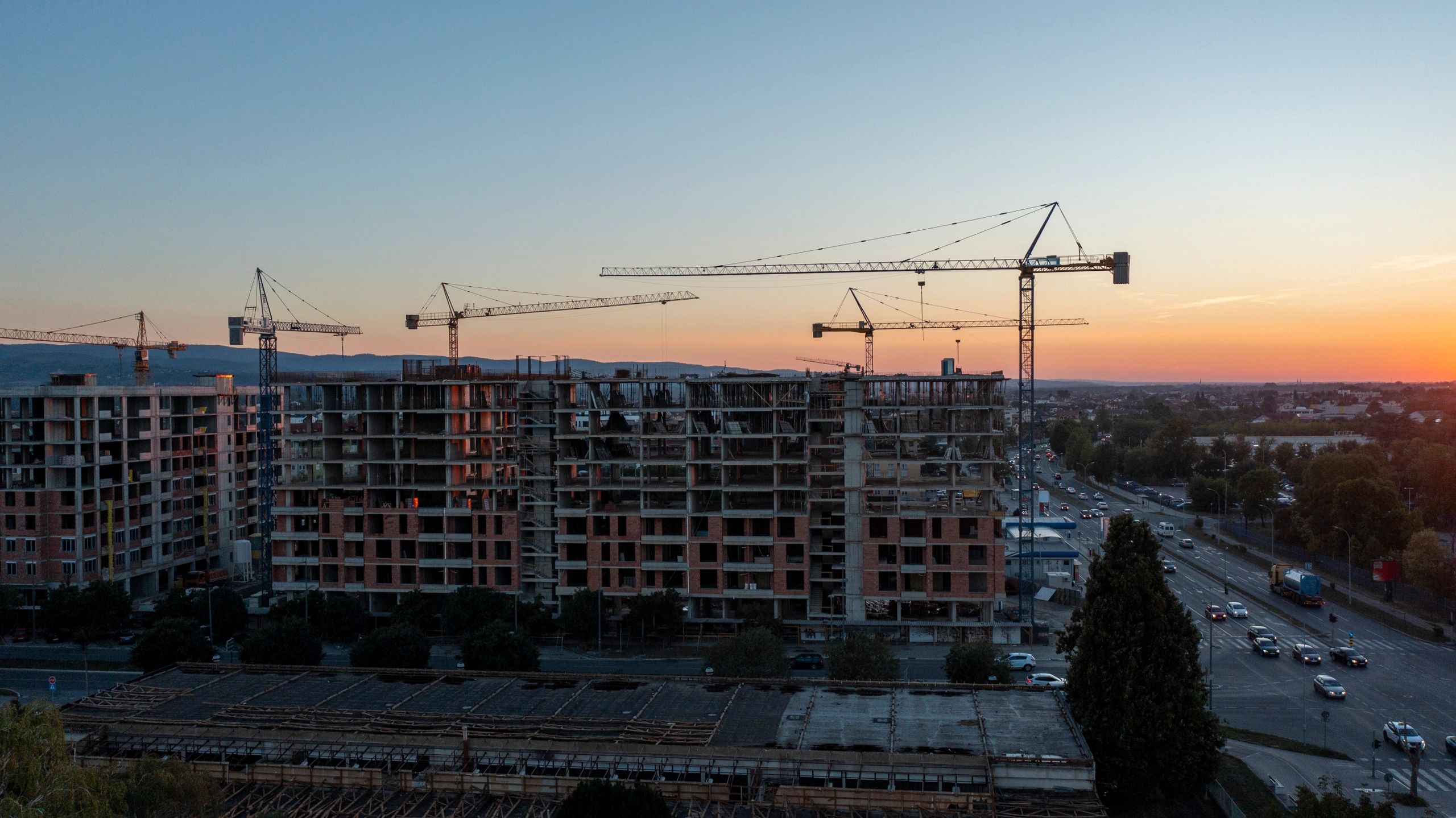 Commercial construction site with cranes at sunset